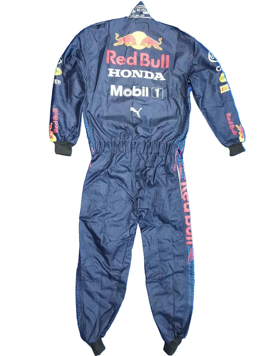 A dark navy Red Bull Racing one-piece jumpsuit with sponsor logos including Red Bull, Honda, Mobil 1, Puma, and Castore, laid flat on a crinkled blue background.