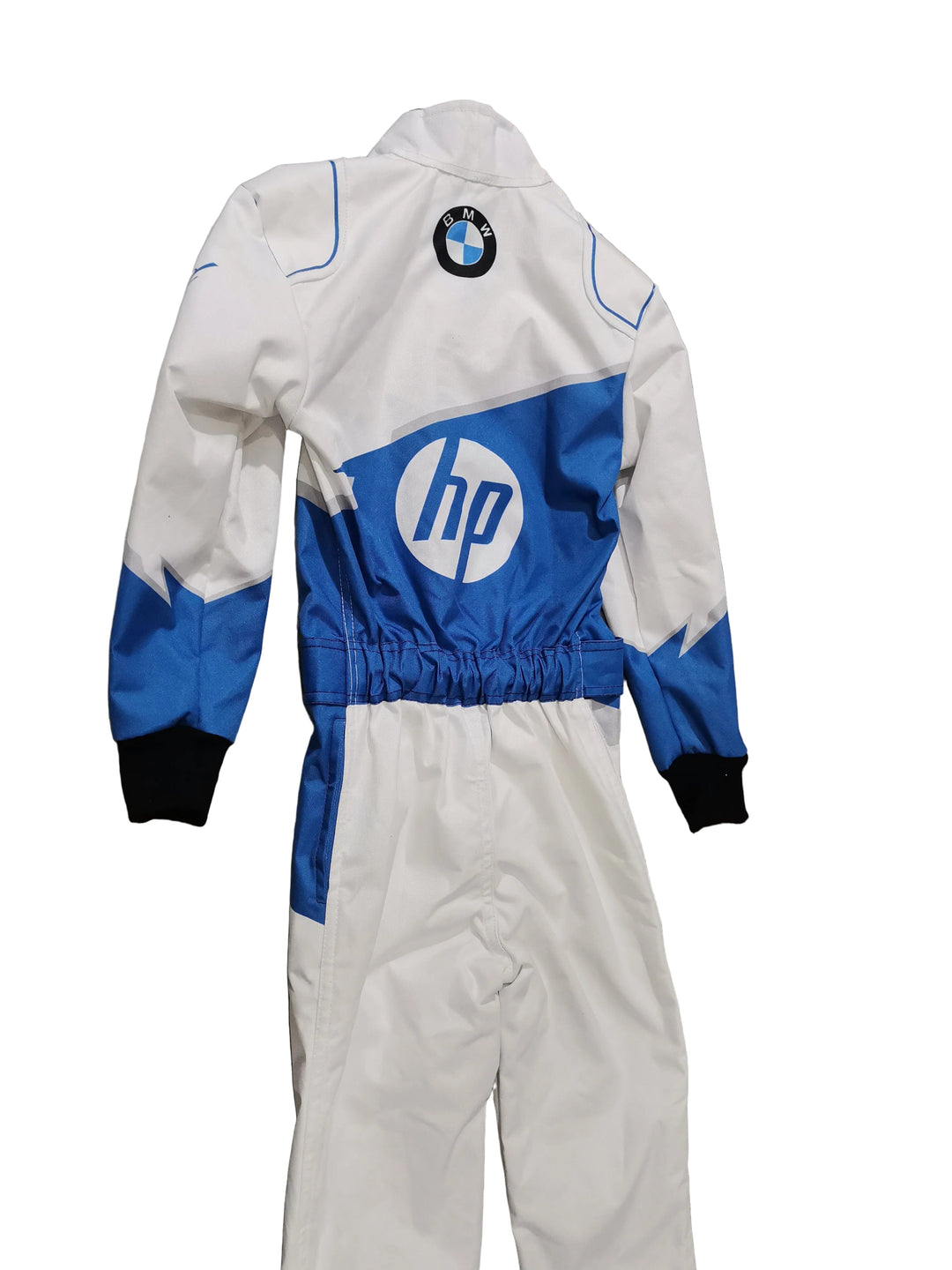 A white and blue racing suit laid flat on a gray marble-patterned floor. The suit features a large HP logo on the chest, a BMW roundel patch on the upper left shoulder, and blue panels on the chest and lower sleeves, finished with black cuffs.