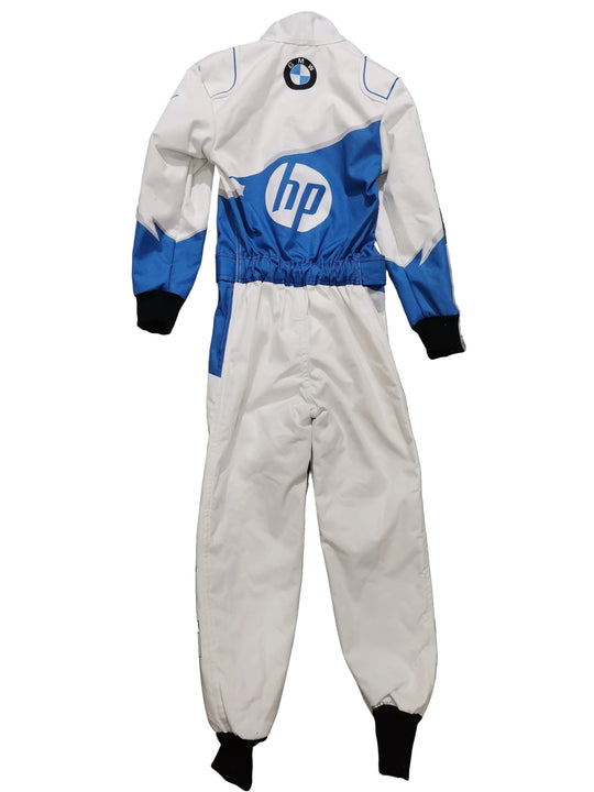 A white, blue, and black racing one-piece jumpsuit laid flat on a gray marble-patterned tile floor. The back of the suit features a large blue HP logo with a white 'hp' text center, a circular BMW roundel patch near the neck, and blue accents on the shoulders and sides.