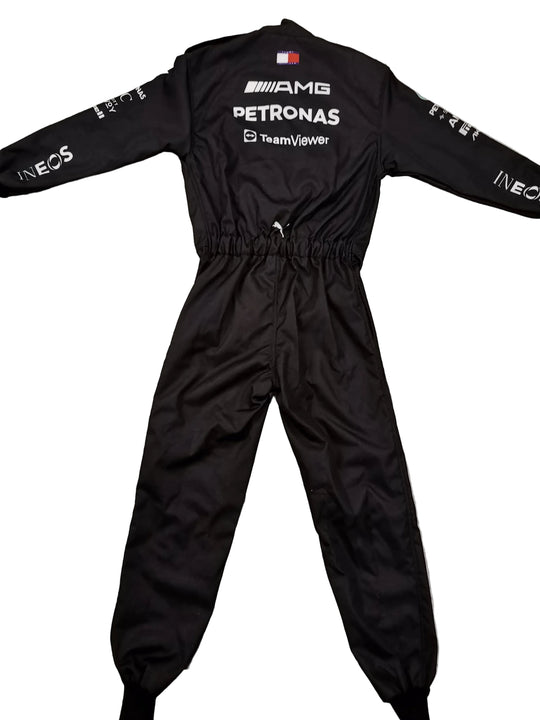 A black long-sleeve racing jumpsuit with sponsor logos including Petronas and Mercedes-AMG, laid flat on a gray marble-patterned tile floor.