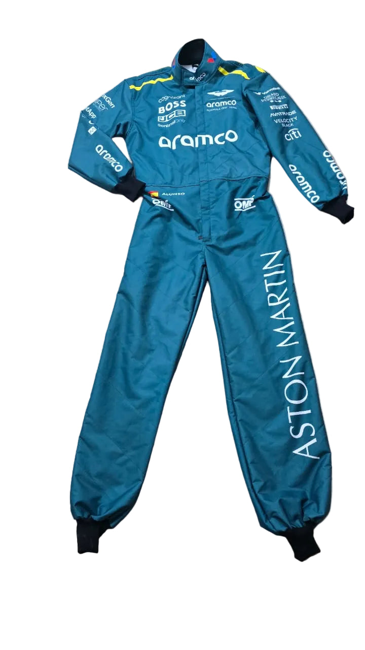 A teal racing suit laid flat on a beige tiled floor, featuring prominent white 'aramco' branding on the chest and 'ASTON MARTIN' printed vertically down the left leg, with sponsor logos on the sleeves and shoulders.
