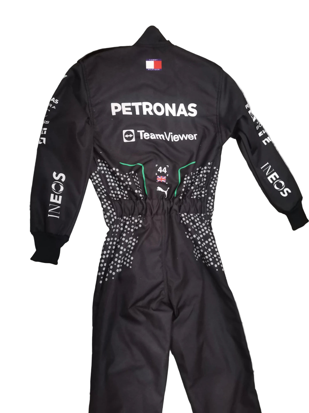 A black Mercedes racing suit with Petronas and TeamViewer branding, laid flat on a gray marble-patterned tile floor.