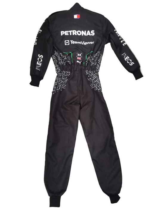 A black Petronas Team F1wear one-piece racing suit with white sponsor logos and silver rhinestone embellishments on the sides, laid flat on a gray marble tiled floor.