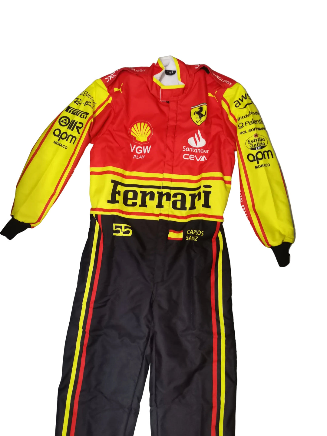 A red and yellow Ferrari racing suit with black pants, laid flat on a gray marble tile floor. The suit features multiple sponsor logos including Shell, VGW, and OPM, and the number 5 on the thigh.
