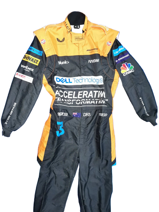 A black and yellow Histon motorsport racing suit with various sponsor logos, including Dell Technologies, Webox, and NBC, laid flat on a crumpled blue background.