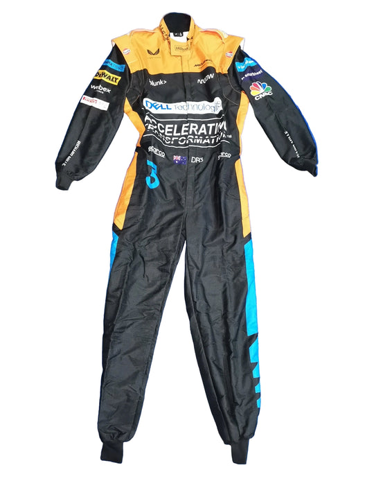 A black and orange racing suit with teal accents and multiple sponsor logos, laid flat on a crinkled blue tarp.