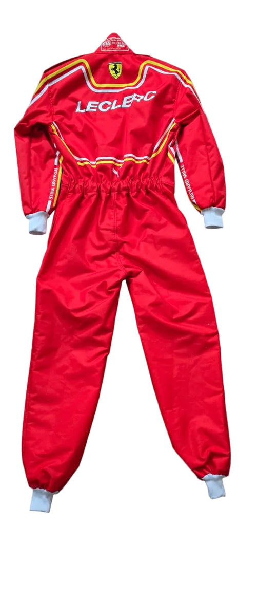 A red Leclerc Ferrari racing suit laid flat on a beige tiled floor. The suit features 'LECLERC' and the Ferrari shield logo on the back, with yellow and white stripes and white cuffs.