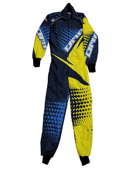 A full-body one-piece racing suit laid flat on a gray marble-patterned tile floor. The suit features a bold color-blocked design with navy blue, bright yellow, and light blue sections, separated by black halftone diamond patterns and white 'ONE' branding on the shoulders and upper chest.