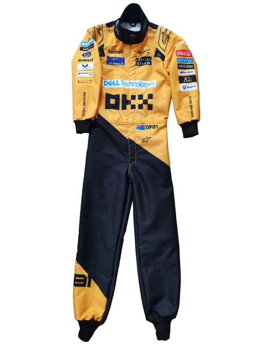 A yellow and black racing suit with multiple sponsor logos, laid flat on a beige stone-tiled floor.