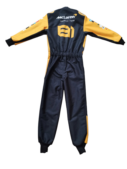 A black and yellow long-sleeve racing jumpsuit laid flat on a beige tiled floor, featuring 'McLaren' and 'F1' branding on the back.